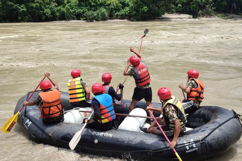 Nepal army personnel cary out a search operation looking for the survivors after two buses were swept by a landslide off the highway and into a swollen river near Simaltal, about 120 kilometers (75 miles) west of the capital Kathmandu, Nepal, Saturday, July 13, 2024. (AP Photo/ Ramesh Paudel)