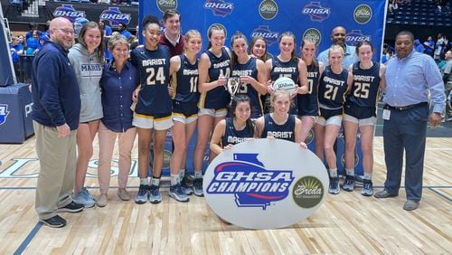 Marist players and coaches pose with the championship trophy after defeating North Forsyth 67-48 in the Class 6A girls basketball final at the Macon Coliseum on March 8, 2024.