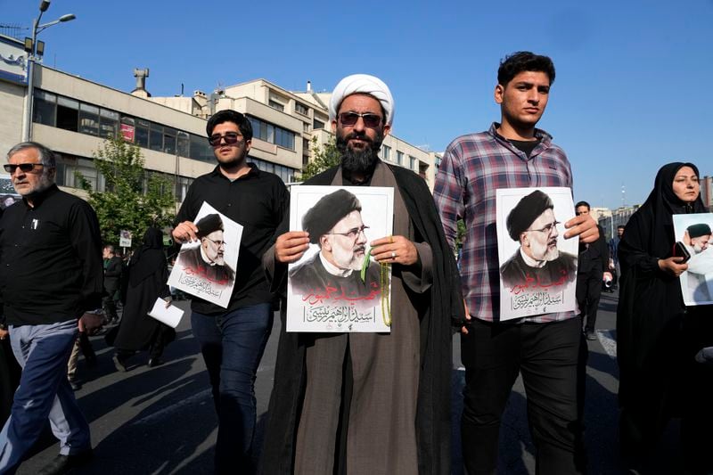 Mourners hold posters of the late Iranian President Ebrahim Raisi during a funeral ceremony for him and his companions who were killed in a helicopter crash on Sunday in a mountainous region of the country's northwest, in Tehran, Iran, Wednesday, May 22, 2024. Iran's supreme leader presided over the funeral Wednesday for the country's late president, foreign minister and others killed in the helicopter crash, as tens of thousands later followed a procession of their caskets through the capital, Tehran. (AP Photo/Vahid Salemi)
