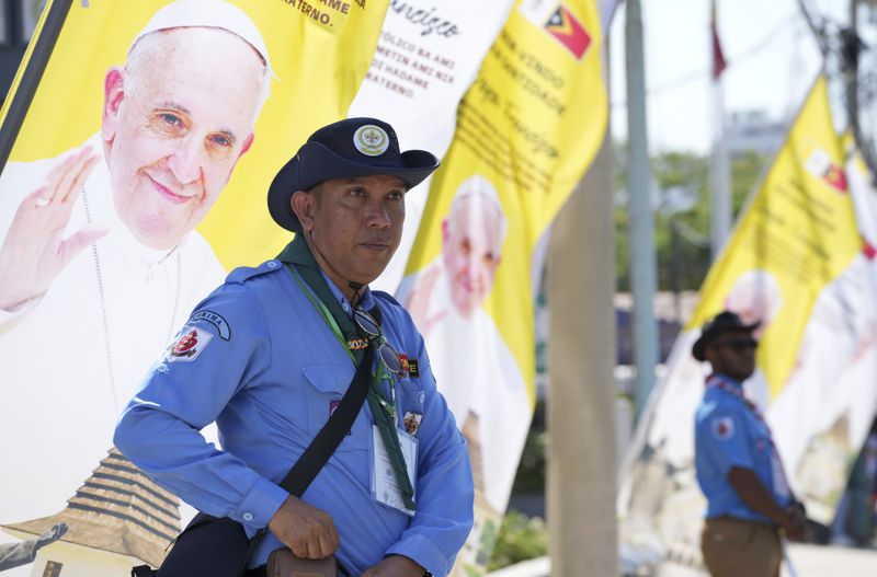 Security persons stand near banners to welcome Pope Francis' visit in Dili, East Timor Monday, Sept. 9, 2024. (AP Photo/Firdia Lisnawati)