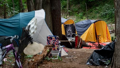 Multiple tents are set up in the woodline next to interstate 85. Tracy Woodard is a social worker with InTown Cares, a homeless advocacy group serving the Atlanta metro area. Friday, May 17, 2024 (Ben Hendren for the Atlanta Journal Constitution)