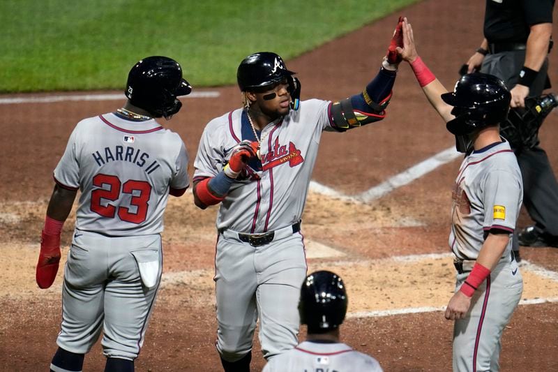 Atlanta Braves' Ronald Acuña Jr., center, is greeted by Michael Harris II (23) and Zack Short, right, after hitting a three-run home run off Pittsburgh Pirates starting pitcher Bailey Falter during the eighth inning of a baseball game in Pittsburgh, Friday, May 24, 2024. (AP Photo/Gene J. Puskar)