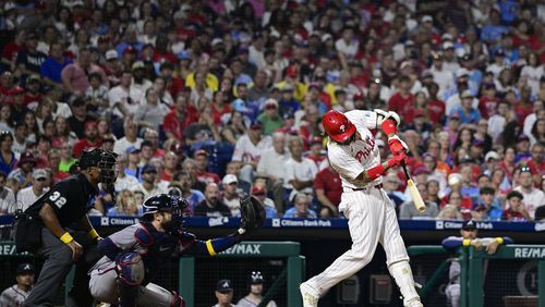 Philadelphia Phillies' Nick Castellanos, right, hits a two-run double off Atlanta Braves' Spencer Schwellenbach during the sixth inning of a baseball game, Sunday, Sept. 1, 2024, in Philadelphia. (AP Photo/Derik Hamilton)