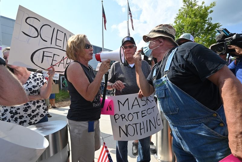 A demonstrator (right) demanding mask-mandate confronts a counter-protester at a rally in the parking lot of Cobb County School District's headquarters on Aug. 12, 2021. (Hyosub Shin / Hyosub.Shin@ajc.com)