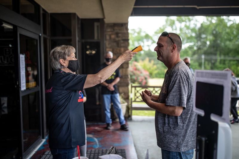 Deborah Holland takes a customer's temperature.  BRANDEN CAMP/SPECIAL