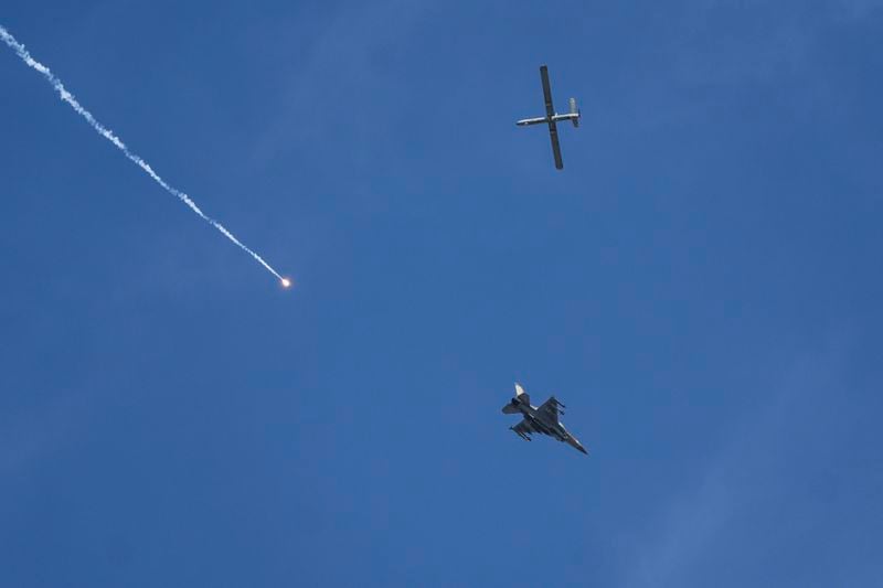 An Israeli fighter jet releases flares, and a drone is seen from Rafah, Gaza Strip, on Tuesday, May 28, 2024. (AP Photo/Abdel Kreem Hana)