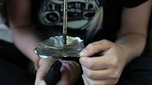 FILE - A homeless woman person smokes fentanyl, June 28, 2024, in Portland, Ore. (AP Photo/Jenny Kane, File)