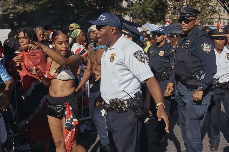 Police move revelers from the street after a shooting on Eastern Parkway, near the corner of Franklin Avenue, during the West Indian Day Parade on Monday, Sept. 2, 2024, in the Brooklyn borough of New York. (AP Photo/Andres Kudacki)