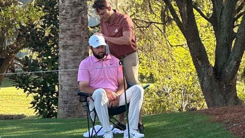 FILE - Scottie Scheffler, seated, gets treatment as he waits to tee off on the 14th hole during the second round of The Players Championship golf tournament Friday, March 15, 2024, in Ponte Vedra Beach, Fla. Scheffler went on to win the tournament. (AP Photo/Doug Ferguson)