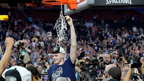 FILE - UConn center Donovan Clingan (32) celebrates cutting the net after their win against Purdue in the NCAA college Final Four championship basketball game, April 8, 2024, in Glendale, Ariz. (AP Photo/David J. Phillip, File)