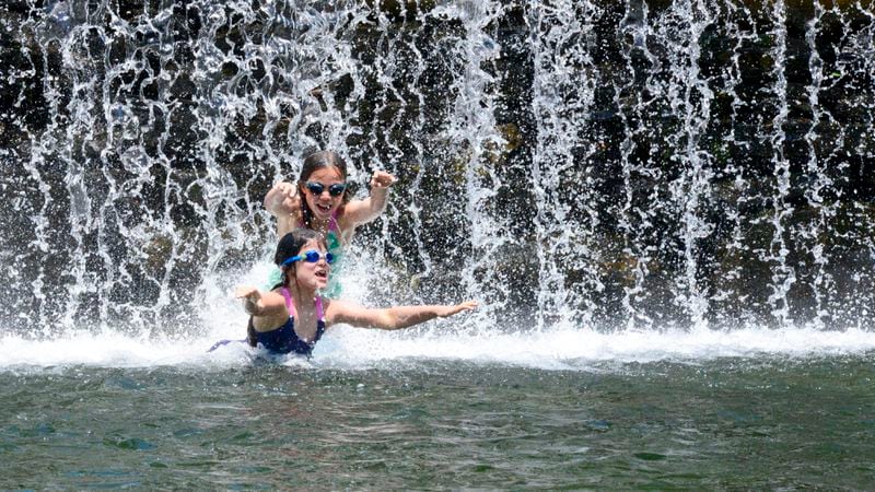 Iris Murdie, 8 and her sister, Finoa, 10, play in the water at the Green River Timber Crib Dam in Guilford, Vt., on Wednesday, June 19, 2024. (Kristopher Radder /The Brattleboro Reformer via AP)