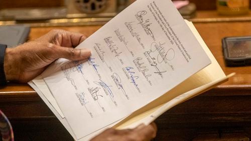 A member of the Georgia electoral college looks over a Certificate of Vote during the official casting of the ballot on Dec. 14 2020, in the Georgia Senate Chambers at the Georgia State Capitol in Atlanta. (Alyssa Pointer/The Atlanta Journal-Constitution)