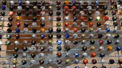 Helmets representing college football teams from across the country are on display at the College Football Hall of Fame.  (AJC file photo)