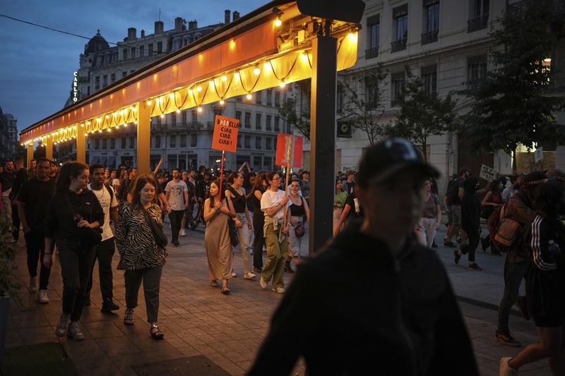 People gather in Lyon, central France, to protest the far-right National Rally, which came out strongly ahead in first-round legislative elections, Sunday, June 30, 2024. France's high-stakes legislative elections propelled the far-right National Rally to a strong but not decisive lead in the first-round vote Sunday, polling agencies projected, dealing another slap to centrist President Emmanuel Macron. (AP Photo/Laurent Cipriani)