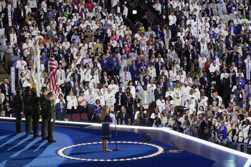 People in the crowd wear white during the Pledge of Alliegence during the Democratic National Convention Thursday, Aug. 22, 2024, in Chicago. (AP Photo/Morry Gash)