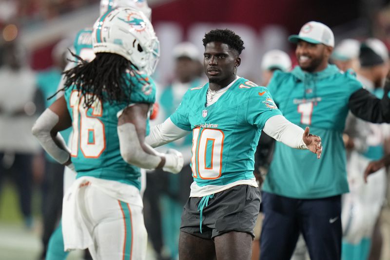 Miami Dolphins wide receiver Tyreek Hill (10) greets players as they come off the field during the second half of a pre season NFL football game against the Tampa Bay Buccaneers, Friday, Aug. 23, 2024, in Tampa, Fla. (AP Photo/Chris O'Meara)