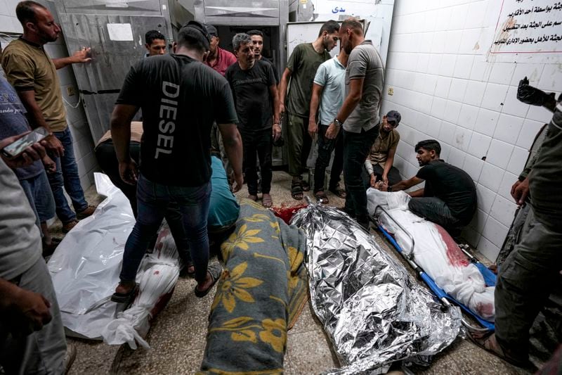 Palestinians check the bodies of their relatives killed in the Israeli bombardment of the Gaza Strip, at a hospital morgue in Deir al-Balah, Sunday, Sept. 1, 2024. (AP Photo/Abdel Kareem Hana)