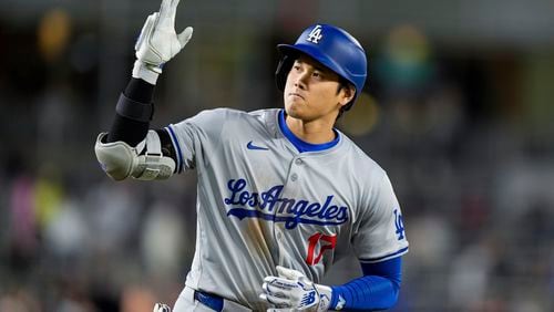 Los Angeles Dodgers designated hitter Shohei Ohtani celebrates as he runs the bases for his solo home run during the ninth inning of a baseball game against the Washington Nationals at Nationals Park, Tuesday, April 23, 2024, in Washington. The Dodgers won 4-1. (AP Photo/Alex Brandon)