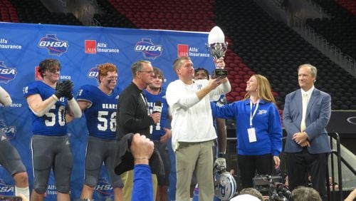 Pierce County Bears coach Ryan Herring hoists the Class 2A Championship Trophy after they beat the Rockmart Yellow Jackets 48-45 in triple overtime on Tuesday, Dec. 12, 2023 at Mercedes-Benz Stadium in Atlanta. (Adam Krohn for the AJC)