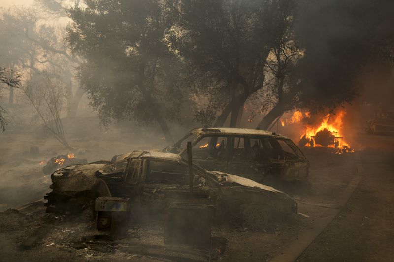 Charred vehicles sit on a property after the Airport Fire swept through Tuesday, Sept. 10, 2024, in El Cariso, an unincorporated community in Riverside County, Calif. (AP Photo/Eric Thayer)