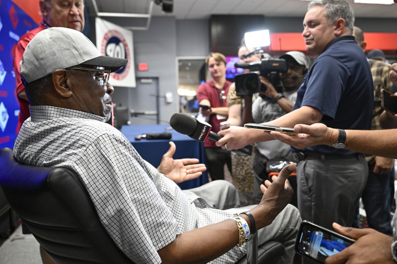 Former player and manager Dusty Baker talks with the media about his son Darren Baker first day in the major leagues with the Washington Nationals before a baseball game with the Chicago Cubs, Sunday, Sept. 1, 2024, in Washington. (AP Photo/John McDonnell)