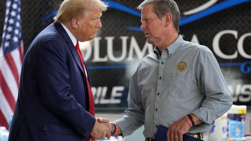 Republican presidential nominee former President Donald Trump shakes hands with Georgia Gov. Brian Kemp after speaking at a temporary relief shelter as he visits areas impacted by Hurricane Helene, Friday, Oct. 4, 2024, in Evans, Ga. (AP Photo/Evan Vucci)