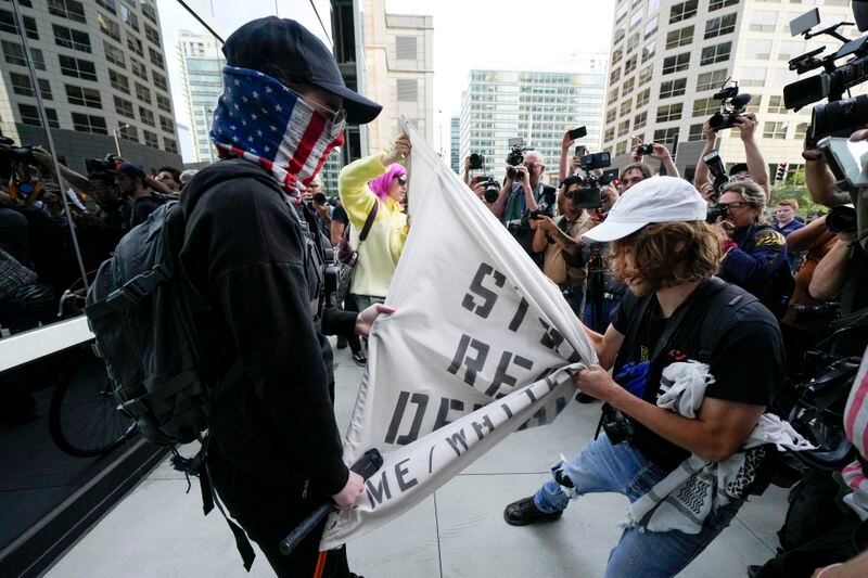 A demonstrator and a counter protester struggle near the Israeli Consulate during the Democratic National Convention Tuesday, Aug. 20, 2024, in Chicago. (AP Photo/Julio Cortez)