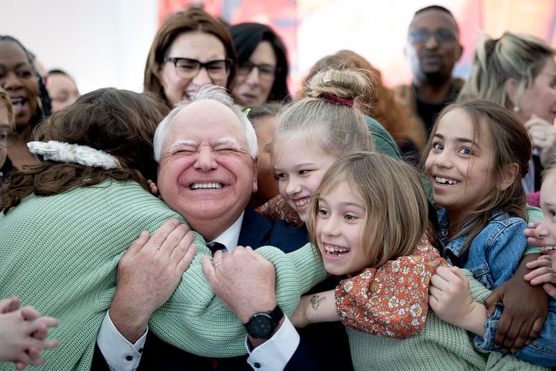 Minnesota Gov. Tim Walz gets a huge hug from students at Webster Elementary after he signed into law a bill that guarantees free school meals for every student in the state's public and charter schools.