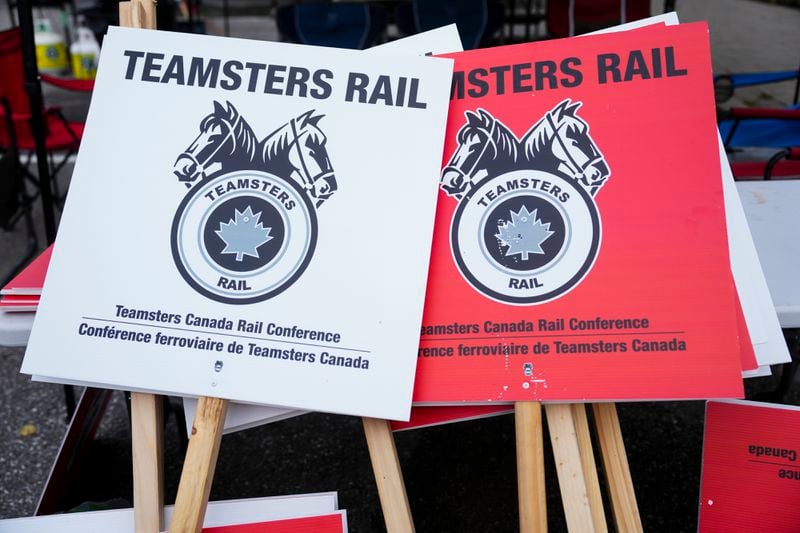 Teamsters Rail placards sit in a pile at a Canadian Pacific Kansas City (CPKC) rail yard in Smiths Falls, Ont., on Thursday, Aug. 22, 2024. (Sean Kilpatrick /The Canadian Press via AP)