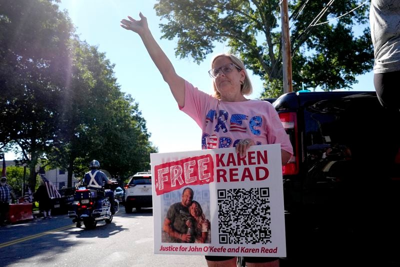 Laura McGillis, of Attleboro, Mass., a supporter of Karen Read, waves to passing cars a block away from Norfolk Superior Court, Tuesday, June 25, 2024, in Dedham, Mass. Karen Read is on trial, accused of killing her boyfriend Boston police Officer John O'Keefe, in 2022. (AP Photo/Steven Senne)