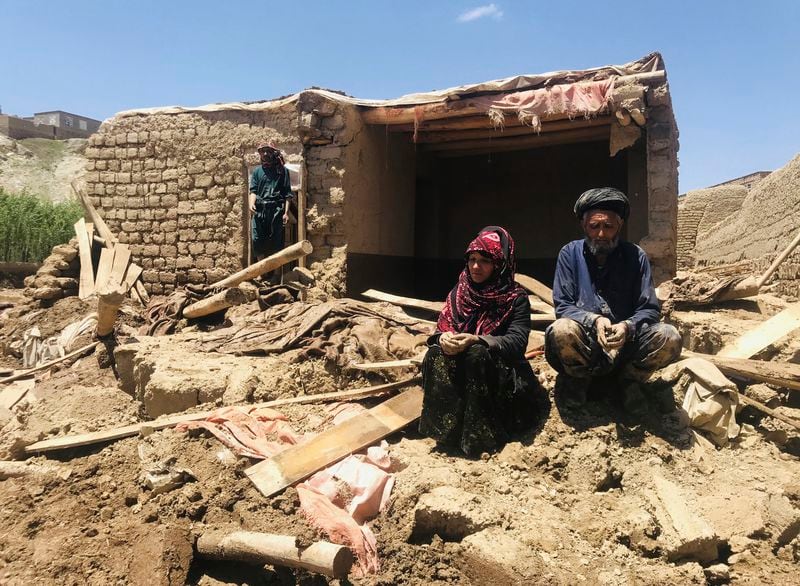 An Afghan couple sit near to their damaged home after heavy flooding in Ghor province in western Afghanistan Saturday, May 18, 2024. Flash floods from heavy seasonal rains in Ghor province in western Afghanistan killed dozens of people and dozens remain missing, a Taliban official said on Saturday, adding the death toll was based on preliminary reports and might rise. (AP Photo/Omid Haqjoo)