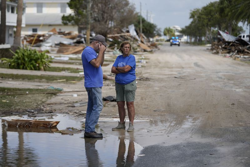 Leslie Sturmer (right), a University of Florida employee, and John Rittenhouse, general manager of the Cedar Key Water and Sewer District, both residents of Cedar Key, Fla., speak in the aftermath of Hurricane Helene on Friday, Sept. 27, 2024. (Gerald Herbert/AP)