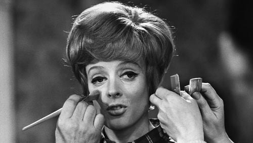 FILE - Make up and hair artists add the finishing touches to British actress Maggie Smith before she faces the camera with Peter Ustinov in the comedy 'Hot Millions' being filmed at Elstree Studios, England, Jan. 12, 1968. Smith has died aged 89. (AP Photo/Bob Dear, File)