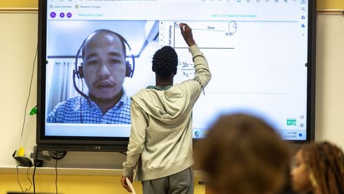 A student writes on a classroom smart board during an 11th grade physics class taught virtually by Bienvenido Oliver at Rockdale Career Academy in Conyers, Georgia, on Sept. 22, 2023. (Arvin Temkar/The Atlanta Journal-Constitution/TNS)