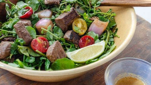 Shaking Beef is a traditional Vietnamese dish made with watercress, tomatoes and marinated sirloin. (Virginia Willis for The Atlanta Journal-Constitution)