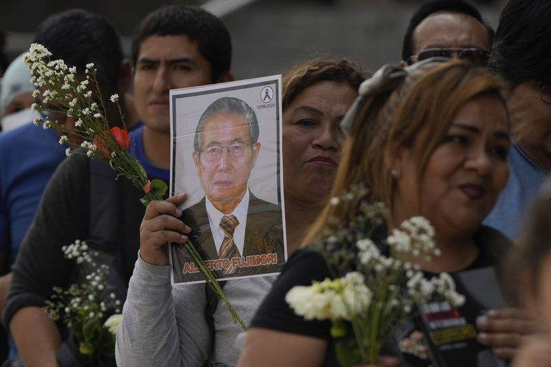 Supporters of former President Alberto Fujimori line up to pay their respects outside a museum where his body is lying in Lima, Peru, Thursday, Sept. 12, 2024. (AP Photo/Guadalupe Pardo)