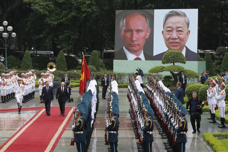 Vietnamese President To Lam, left on red carpet, and his Russian counterpart Vladimir Putin, right on red carpet, review the guard of honor at the Presidential Palace in Hanoi, Vietnam, Thursday, June 20, 2024. (AP Photo/Minh Hoang, Pool)