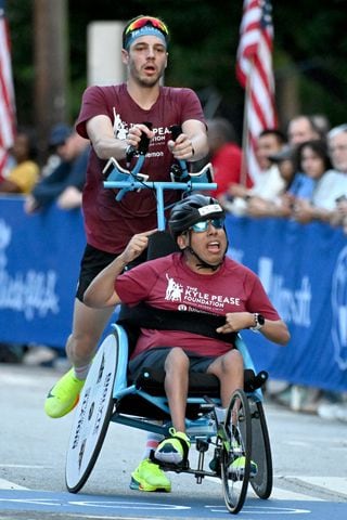 Top Push Assist competitors Ricardo Aranda and Evan Fragnitoi cross the finish line with a time of 37:04  during the 55th running of the Atlanta Journal-Constitution Peachtree Road Race on Thursday, July 4, 2024.  (Hyosub.Shin / ajc.com)