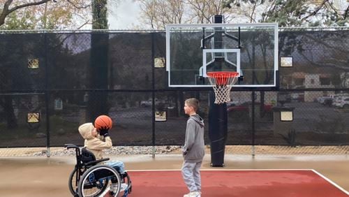 This undated photo provided by Jasculca Terman Strategic Communications shows twin brothers Cooper and Luke Roberts playing basketball. Cooper was a victim of the 2022 Fourth of July parade shooting in Highland Park, Ill., and remains paralyzed from the waist down. Keely Roberts, the mother of the youngest victims of the Fourth of July parade shooting, which left one of her twin sons — now 10 — paralyzed from the waist down, will talk to the media Wednesday, July 3, 2024, about what it means to survive the horror two years later. (The Roberts Family/Jasculca Terman Strategic Communications via AP)
