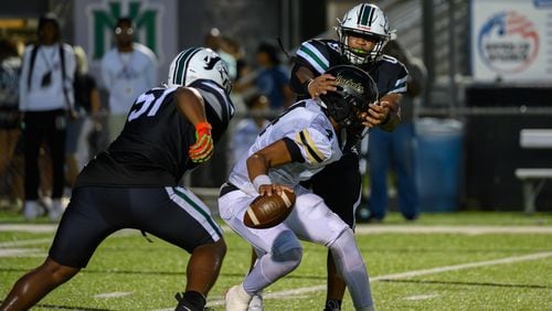 Jaden Duckett, quarterback for Sprayberry High School, escapes a sack during the Sprayberry at Kennesaw Mountain high school football game in Kennesaw, GA on Aug. 30, 2024. (Jamie Spaar for the Atlanta Journal Constitution)