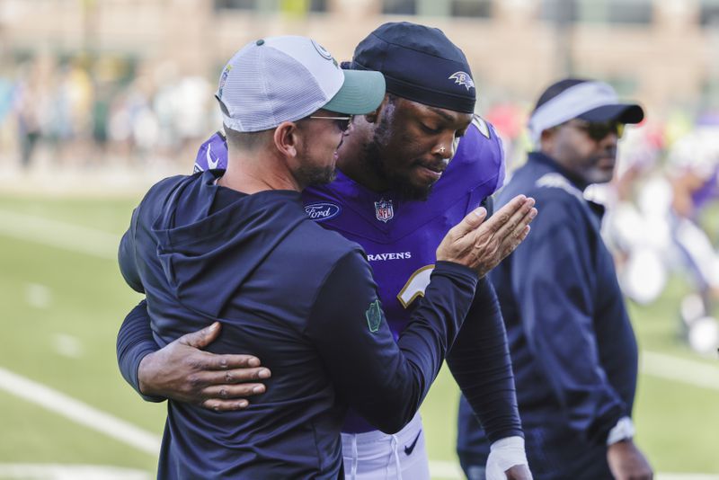 Green Bay Packers head coach Matt LaFleur and Baltimore Ravens running back Derrick Henry (22) greet each other on the field during an NFL football joint training camp practice Thursday, Aug. 22, 2024, in Green Bay, Wis. (AP Photo/Matt Ludtke)