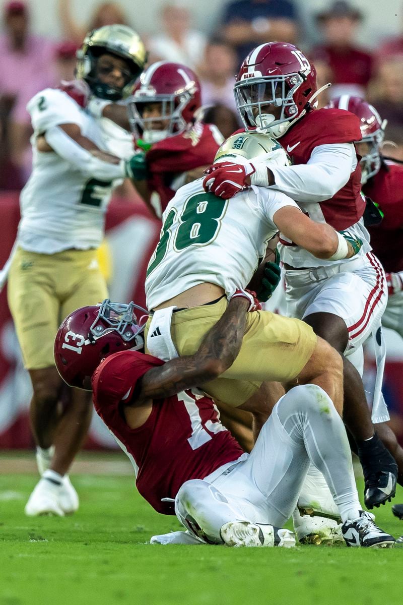 Alabama defensive back Malachi Moore (13) and linebacker Justin Jefferson (15) tackle South Florida wide receiver Sean Atkins (38) during the first half of an NCAA college football game, Saturday, Sept. 7, 2024, in Tuscaloosa, Ala. (AP Photo/Vasha Hunt)