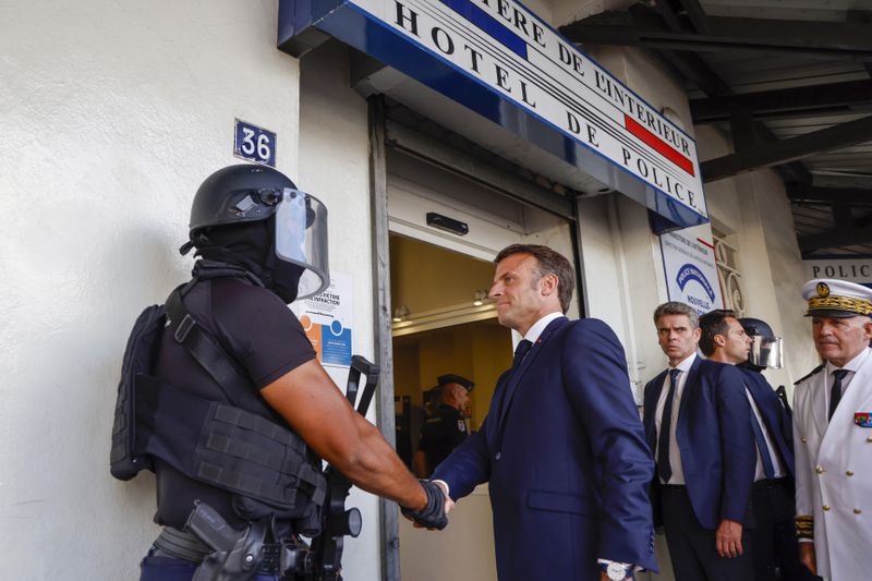 French President Emmanuel Macron shakes hands with a policeman upon his arrival at the central police station in Noumea, New Caledonia, Thursday, May 23, 2024. Macron has met with local officials in riot-hit New Caledonia, after crossing the globe in a high-profile show of support for the French Pacific archipelago gripped by deadly unrest.(Ludovic Marin/Pool Photo via AP)