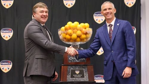 Georgia head coach Kirby Smart and Florida State head coach Mike Norvell pose in front of the Orange Bowl trophy during the head coaches joint press conference at the Le Meridien Dania Beach Hotel, Friday, Dec. 29, 2023, in Fort Lauderdale, Florida. (Jason Getz / Jason.Getz@ajc.com)