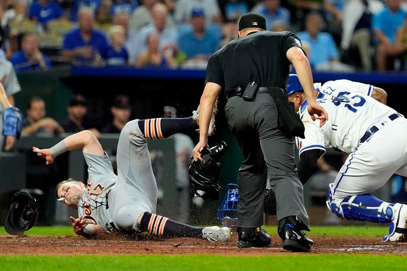 Detroit Tigers' Jace Jung (17) beats the tag by Kansas City Royals catcher Salvador Perez to score on a double by Trey Sweeney during the third inning of a baseball game Wednesday, Sept. 18, 2024, in Kansas City, Mo. (AP Photo/Charlie Riedel)