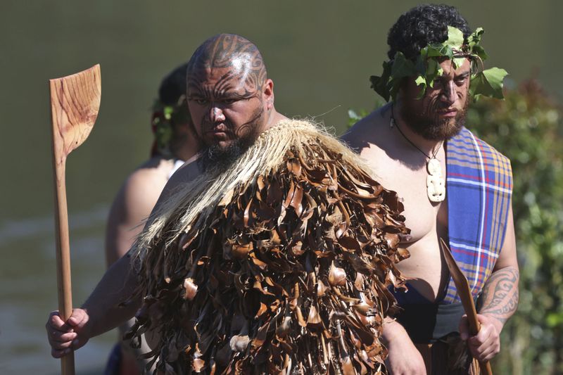 Warriors wait to receive the body of the Māori king, Kingi Tuheitia, next to the Waikato River where he will be carried up Taupiri Mountain for burial at Ngaruawahia, New Zealand, Thursday, Sept 6, 2024. (AP Photo/Alan Gibson)