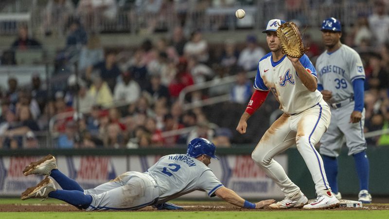 Kansas City Royals outfielder Garrett Hampson, left, slides into first base before Atlanta Braves first baseman Matt Olson, right, catches the ball in the eighth inning of a baseball game, Saturday, Sept. 28, 2024, in Atlanta. (AP Photo/Jason Allen)