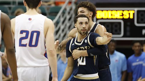 While being held by Georgia Tech guard Jordan Usher (4), guard Jose Alvarado (10) reacts after making a three-point shot over Boise State during the second half Sunday, Dec. 22, 2019, in Honolulu.