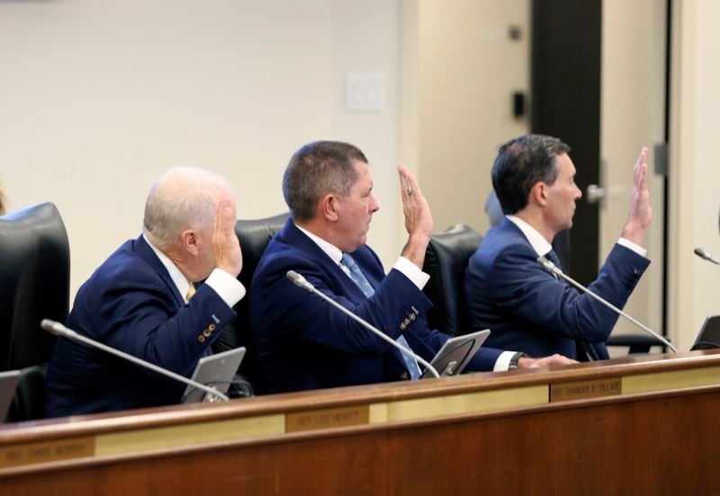 Santee Cooper CEO Jimmy Staton, left, Dominion Energy South Carolina President Keller Kissam, center, and Duke Energy's utility operations in South Carolina President Mike Callahan, right, are sworn in before testifying before a South Carolina Senate committee planning to write a comprehensive energy bill in 2025. in Columbia, S.C., on Thursday, Aug. 22 2024. (AP Photo/Jeffrey Collins)