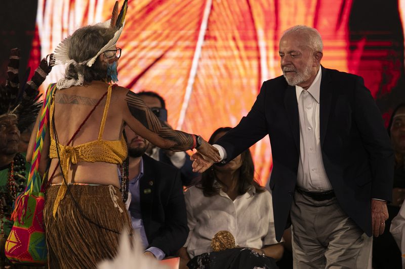 Brazil's President Luiz Inacio Lula da Silva, right, greets Indigenous leader Yakuy Tupinamba during a ceremony celebrating the return of the Indigenous Tupinamba people's sacred cloak to Brazil, in Rio de Janeiro, Thursday, Sept. 12, 2024. The garment, made from bird feathers and plant fibers, was repatriated to Brazil after having spent more than 300 years in the National Museum of Denmark. (AP Photo/Bruna Prado)